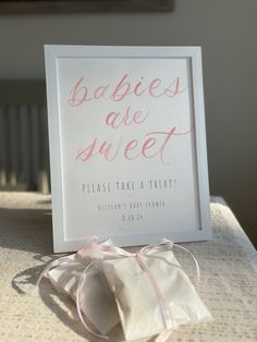 there is a sign that says babies are sweet on the table next to a bag