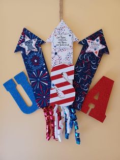 an american flag decoration hanging on the wall with fourth of july written in red, white and blue