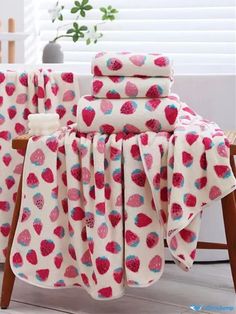 the strawberry print blanket is on top of a chair