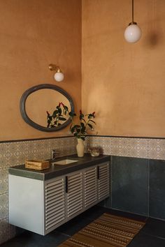 a bathroom with a sink, mirror and rug on the floor in front of it