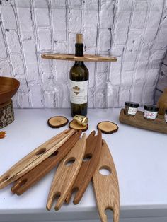 several wooden spoons and knives on a table next to a bottle of wine