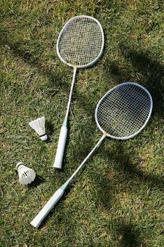 two badminton rackets laying on the grass