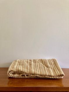 a brown and white striped blanket sitting on top of a wooden table