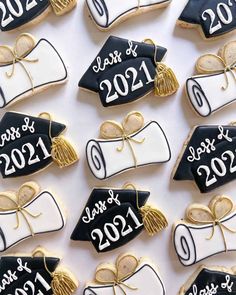 decorated cookies with graduation caps and tassels are arranged on a white tablecloth