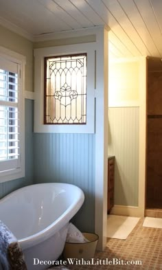 a bath tub sitting next to a window in a bathroom