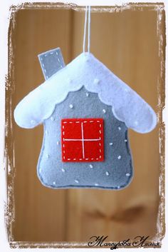 a felt house ornament hanging from a string