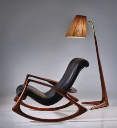 a modern rocking chair with a lamp on the floor in front of it's back