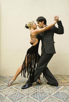 a man and woman are dancing together in front of a sign that says argemina