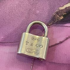 a close up of a padlock on a purple fabric with the word't & t'written on it