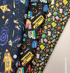 three different types of children's fabric with school bus, rocket ship and rockets on them