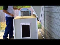 a man standing next to a small air conditioner on top of a wooden box