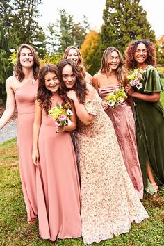 a group of women standing next to each other on top of a lush green field