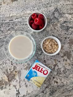 yogurt, granola, and raspberries in bowls on a granite countertop