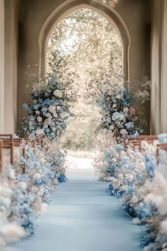 the aisle is decorated with blue and white flowers