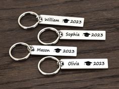 three personalized key chains with graduation caps on them