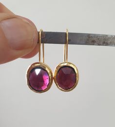 Garnet earrings, January birthstone earrings, drop gold Garnet earrings, red gemstone earrings, oval earrings, January birthday earrings These red, oval Garnet earrings were made in a simple, classic and chic design to create your go-to earrings for days and nights. These gold red gemstone earrings were 100% handmade and are a perfect gift for those celebrating their birthdays in January. Garnet is the official January birthstone and shines beautifully in the gold setting in a deep wine-red colo Ruby Earrings In Yellow Gold For Gift, Ruby Yellow Gold Earrings For Gift, Yellow Gold Ruby Earrings For Gift, Oval Birthstone Earrings For Formal Occasions, Oval Yellow Gold Earrings Gift, Oval Ear Wire Earrings For Anniversary, Gold Earrings With Ruby Birthstone, Gold Ruby Earrings With Birthstone, Yellow Gold Oval Earrings With Birthstone