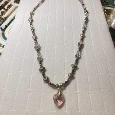 This necklace is a blend of silver alloy hearts, flowers and butterflies mixed with silver and pink crystal beads. The centerpiece, a beautifully polished heart-shaped pink crystal pendant, that radiates an array of colors that dance in the light. Each bead and charm is meticulously arranged to create not just a piece of jewelry but a work of art that graces the neckline. Materials: Silver butterfly, flower and heart beads Heart-shaped gemstone pendant Dimensions: Necklace Length: 18 inches Pendant Size: 1 inch Lobster clasp Silver Heart Crystal Necklace, Silver Heart Charm Crystal Necklace For Valentine's Day, Pink Crystal Heart Pendant Jewelry, Silver Crystal Necklace With Heart Charm Pendant, Crystal Beaded Jewelry For Valentine's Day, Silver Crystal Necklace With Heart Beads, Silver Crystal Necklace With Heart Pendant, Silver Crystal Necklace With Heart Charm, Elegant Pink Heart Necklace With Heart Beads