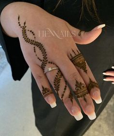 a woman's hand with henna tattoos on it