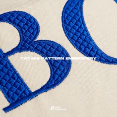 the letters b and d are made out of blue thread on a white t - shirt