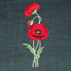 two red flowers with green leaves on a black background, embroidered onto the side of a piece of cloth