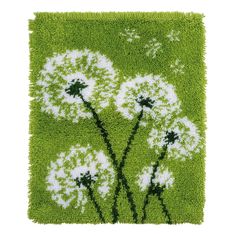 a green rug with white dandelions in the center on top of it, against a white background