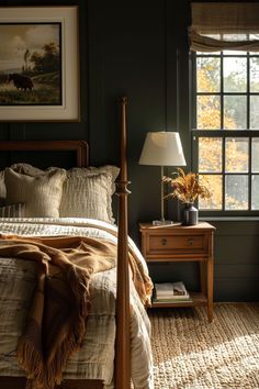 a bed sitting next to a window with a lamp on top of the night stand