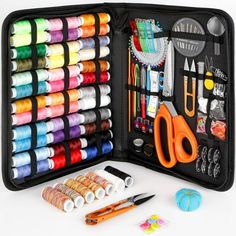 an open case filled with lots of crafting supplies next to scissors and thread spools