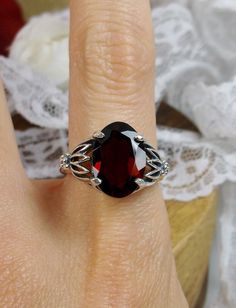 Natural Garnet Ring Tiki Design#122 Custom Made This is a brand new stunning Art Nouveau and Gothic-inspired sterling silver filigree ring. The VS to VVS oval full cut high quality genuine natural garnet is 14mm (9/16th of an inch) by 10mm (3/8 inch) in dimension... The natural 6.5ct to 7ct garnet has a lovely deep red, Merlot color, simply stunning! The inside of the band is marked 925 for sterling. Notice the beautiful filigree swirl like craftsmanship of the silver setting. This is an exquisi Oval Ruby Ring In White Gold For Gift, Oval Cabochon Garnet Jewelry For Anniversary, Oval Red Garnet Jewelry, Anniversary Garnet Oval Cabochon Jewelry, Formal Oval Garnet Jewelry, Red Sterling Silver Oval Cabochon Jewelry, Oval Garnet Ring Hallmarked, Exquisite Silver Oval Ruby Ring, Marquise Garnet Jewelry For Gift