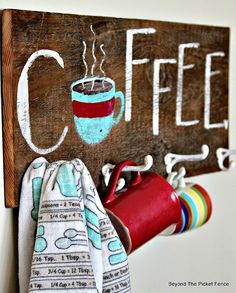 a wooden sign that says coffee and two cups hanging from it's hooks on the wall