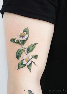 a woman's arm with flowers and leaves tattooed on the left side of her body