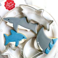 three cookies shaped like sharks on a plate