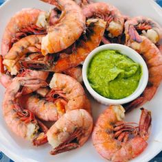 a white plate topped with shrimp and guacamole