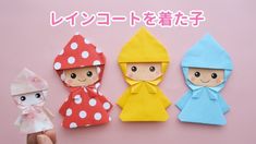 three small paper dolls are shown in different colors and sizes, one is wearing a raincoat