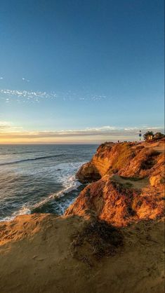 the sun is setting over the beach and ocean