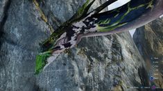 an animal with green and black paint on it's body sitting on top of a rock