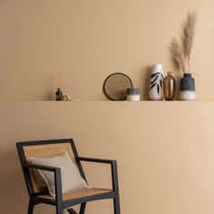 a chair and some vases on a shelf