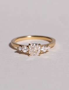 three stone diamond ring in yellow gold with diamonds on the sides and an oval band