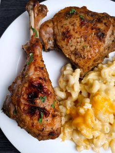 two pieces of chicken, macaroni and cheese on a white plate