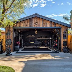 an outdoor garage with lots of equipment in the back ground and trees on either side