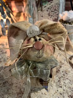 a small stuffed animal wearing a hat and bow tie on top of a countertop