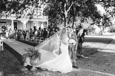 a bride and groom walking down the aisle at their outdoor wedding ceremony in black and white