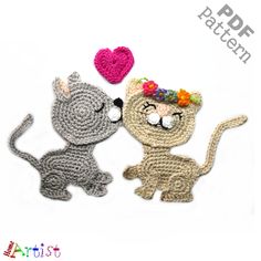 two crocheted cats with hearts on their heads, one is gray and the other is white