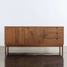 the sideboard is made out of wood and has three drawers on one end, with two