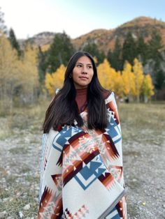 a woman in a blanket is standing outside