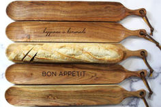 four wooden cutting boards with different types of bread on them and the words bon appeti written in cursive writing