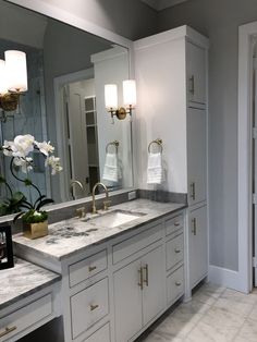 a bathroom with double sinks and marble counter tops