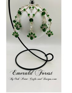 a green and white beaded necklace on a black cord with the words emerald forest written below it