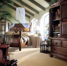 a bedroom with a bed, dressers and plants in the corner on the floor