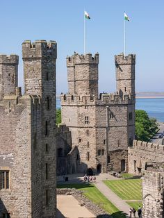 an old castle with two flags on the top and one flag flying in the air