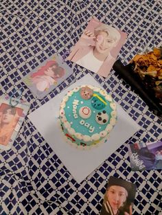 a birthday cake sitting on top of a blue and white table cloth with pictures around it